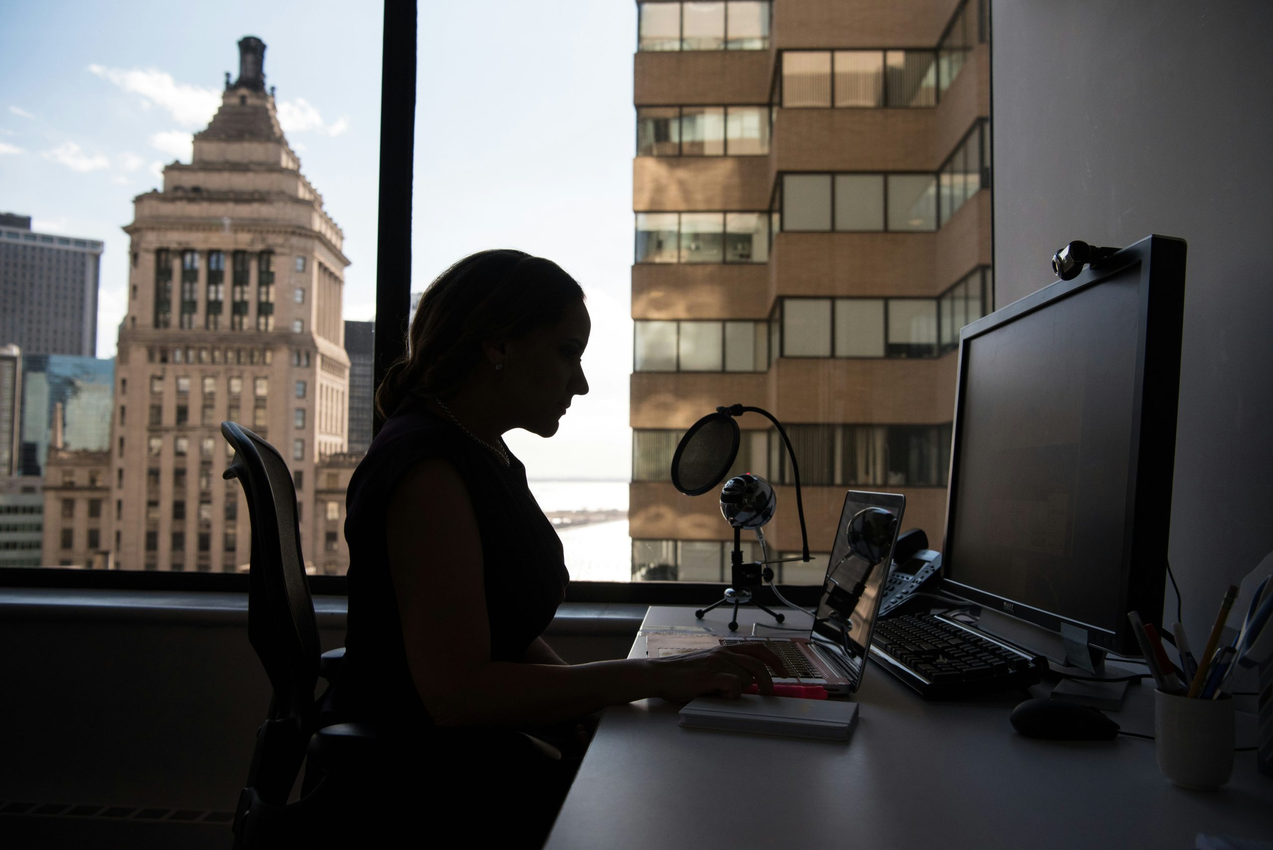 woman in tech working on laptop in shadows